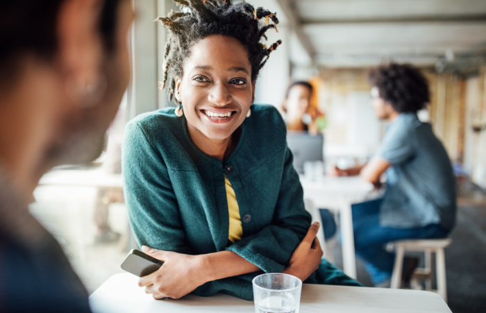 Woman smiling while speaking colleague