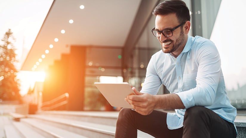 Portrait of businessman in glasses holding tablet