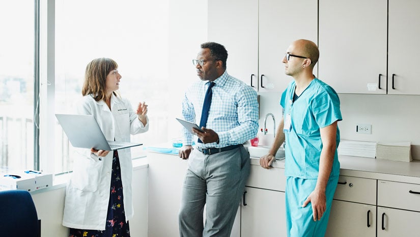 Doctors talking in office breakroom.