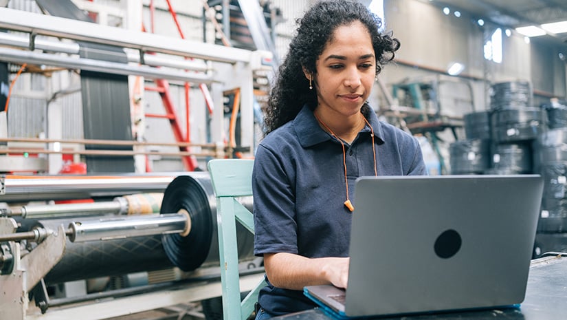 Engineer working on laptop in plastic recycling factory