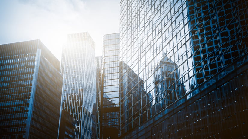 Reflection of city skyline off a glass building.