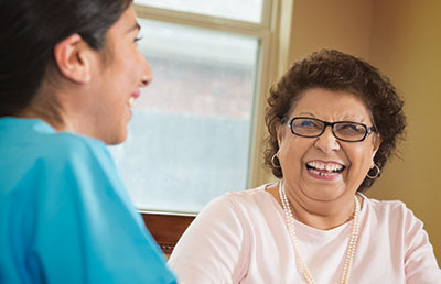 Senior Woman Smiling at Healthcare Worker