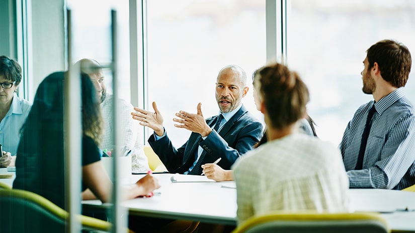 Mature businessman leading meeting in office