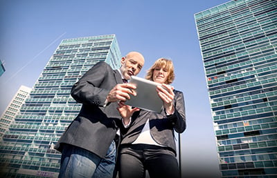 Two-People-Viewing-Tablet-Apartment-Building.jpg